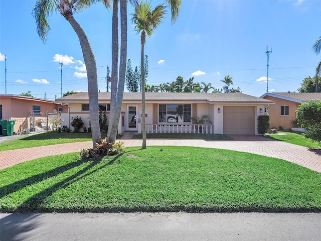 single story home with covered porch, a garage, and a front lawn