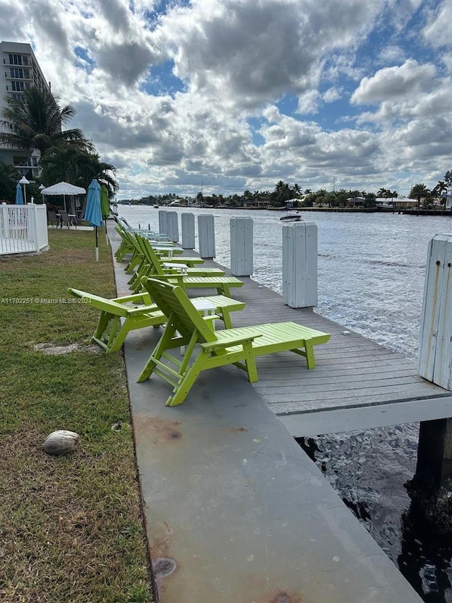 dock area with a lawn and a water view