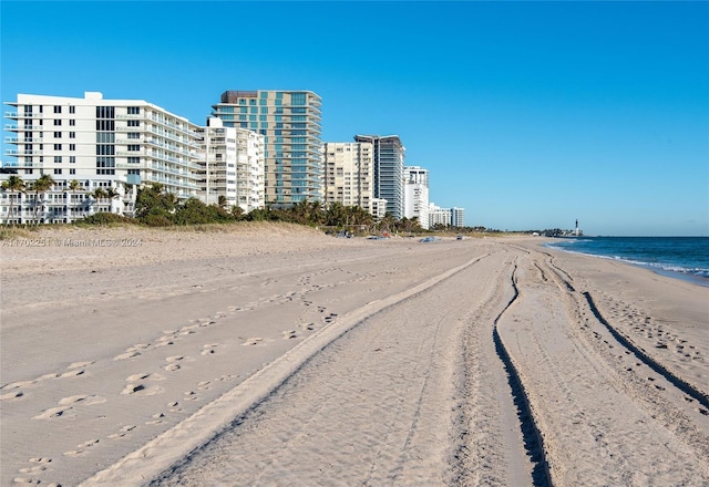 view of building exterior with a water view and a view of the beach