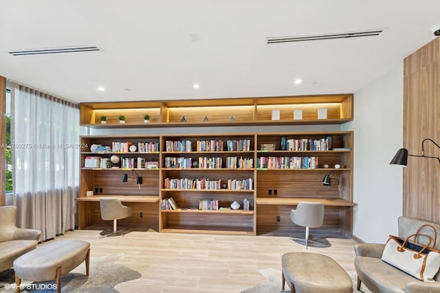 living area with built in desk and light hardwood / wood-style floors