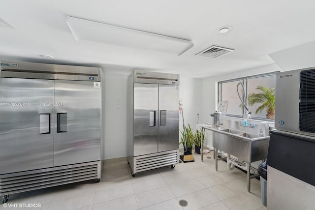 interior space featuring built in fridge, sink, and light tile patterned floors