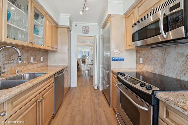 kitchen featuring light hardwood / wood-style floors, light stone countertops, sink, and appliances with stainless steel finishes