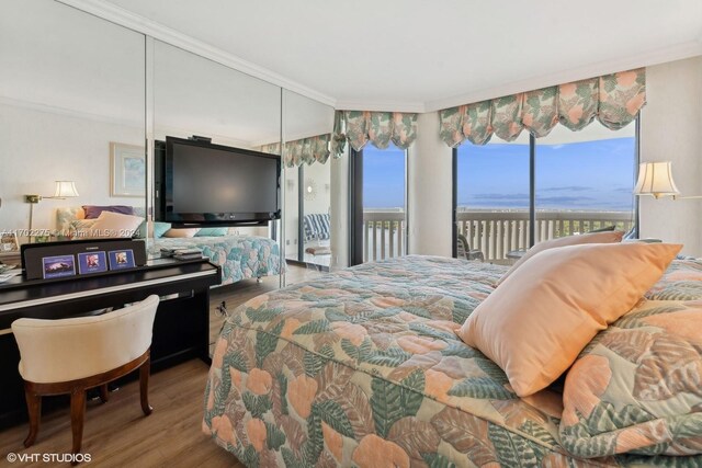 bedroom featuring access to exterior, crown molding, and wood-type flooring