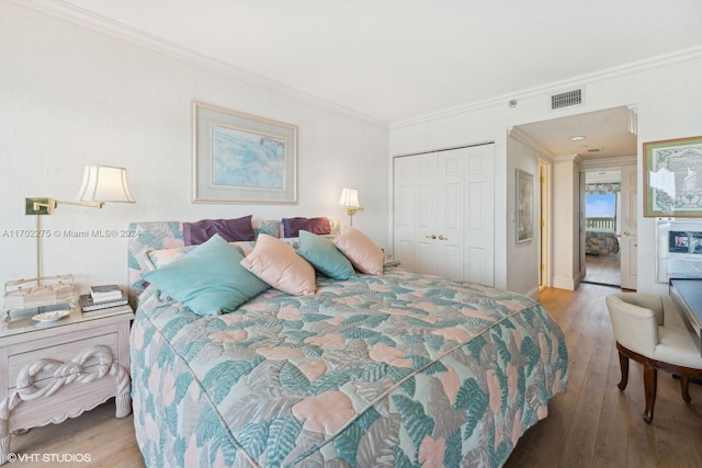 bedroom featuring hardwood / wood-style flooring, a closet, and crown molding