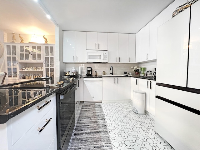 kitchen featuring backsplash, sink, white cabinets, and white appliances