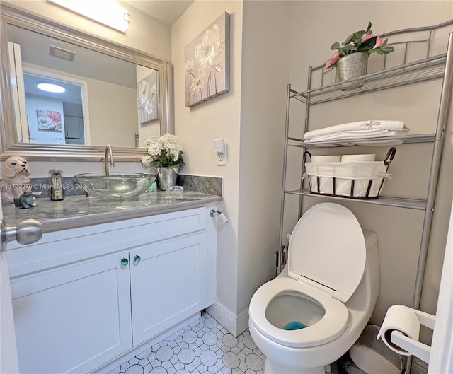 bathroom with tile patterned flooring, vanity, and toilet