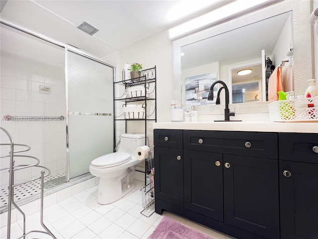 bathroom with tile patterned flooring, vanity, a shower with door, and toilet