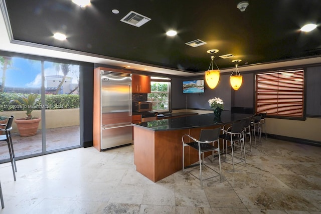 bar featuring a raised ceiling, ornamental molding, hanging light fixtures, and appliances with stainless steel finishes