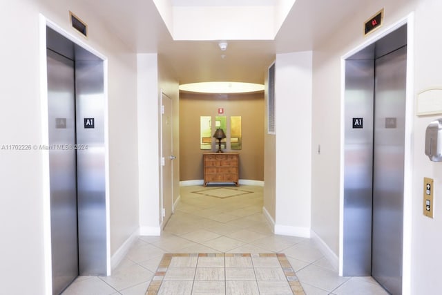 corridor featuring light tile patterned flooring and elevator