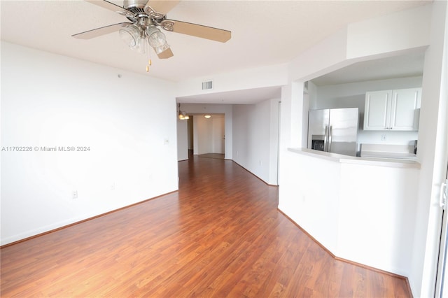 empty room with dark hardwood / wood-style flooring and ceiling fan with notable chandelier