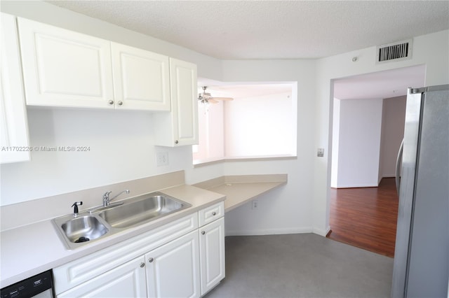 kitchen with a textured ceiling, ceiling fan, sink, white refrigerator, and white cabinets