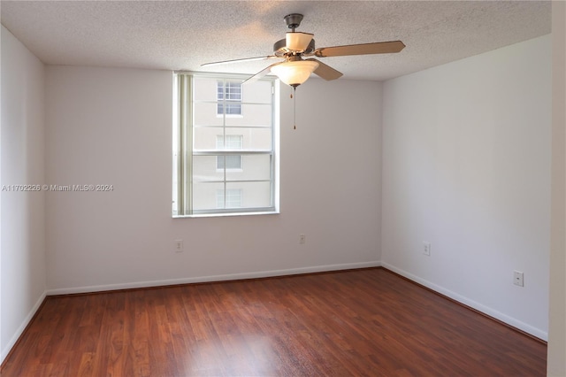 spare room featuring dark hardwood / wood-style floors, ceiling fan, and a textured ceiling