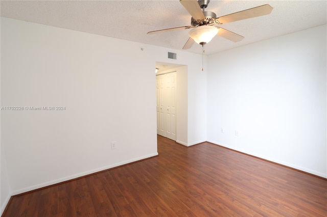 empty room featuring ceiling fan, dark hardwood / wood-style flooring, and a textured ceiling