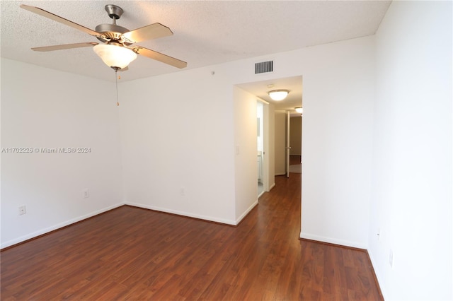 empty room with a textured ceiling, ceiling fan, and dark wood-type flooring