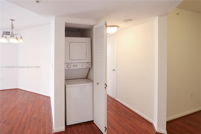 washroom with a chandelier, stacked washer / dryer, and dark wood-type flooring