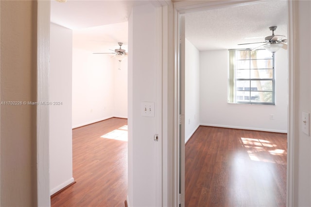 corridor featuring a textured ceiling and hardwood / wood-style flooring