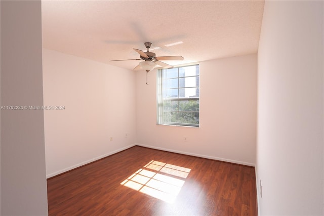 unfurnished room with a textured ceiling, ceiling fan, and dark wood-type flooring