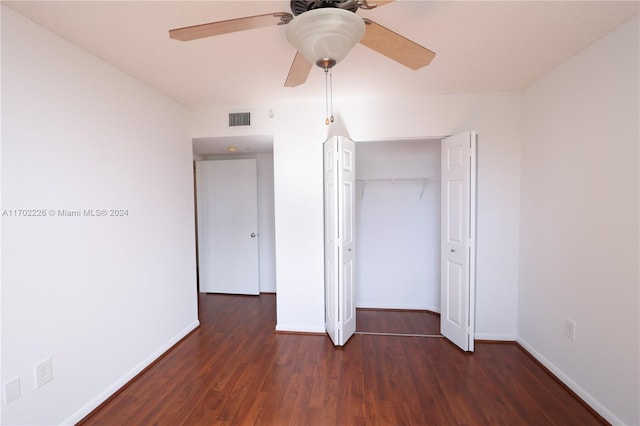 unfurnished bedroom with ceiling fan, dark wood-type flooring, and a closet