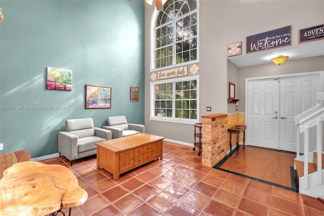 living room with wood-type flooring and a towering ceiling