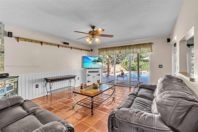 living room featuring tile patterned flooring, a textured ceiling, and ceiling fan