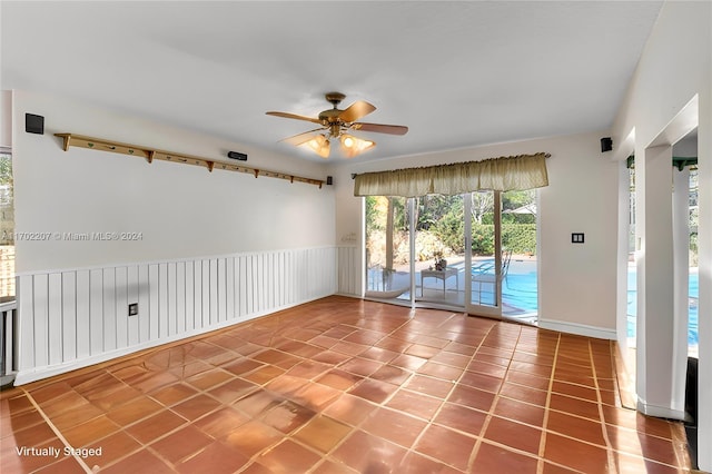 tiled empty room featuring ceiling fan