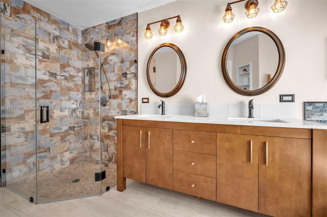 bathroom with hardwood / wood-style floors, vanity, and a shower with door