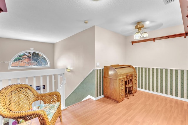 sitting room with a textured ceiling, hardwood / wood-style flooring, and ceiling fan