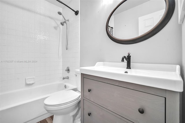 full bathroom with hardwood / wood-style floors, vanity, toilet, and tiled shower / bath