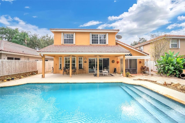 back of house featuring ceiling fan, a fenced in pool, and a patio