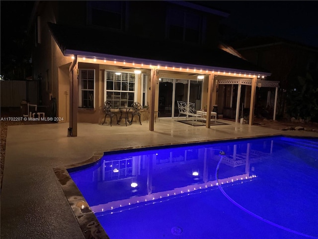 pool at twilight featuring a patio