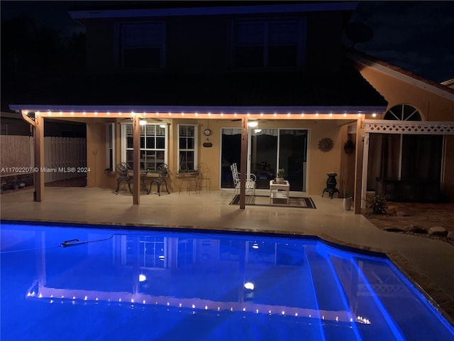 pool at twilight with a patio