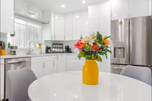 kitchen featuring white cabinetry, sink, and appliances with stainless steel finishes