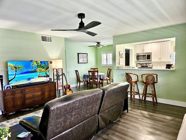 living room featuring dark hardwood / wood-style flooring and ceiling fan