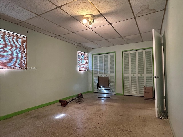 empty room featuring a paneled ceiling and carpet floors