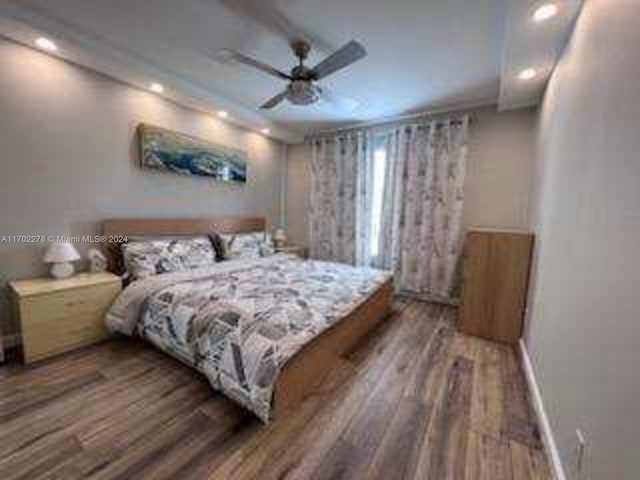 bedroom with dark hardwood / wood-style flooring and ceiling fan