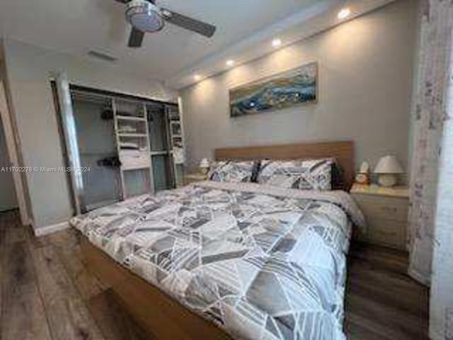 bedroom featuring ceiling fan, dark wood-type flooring, and a closet