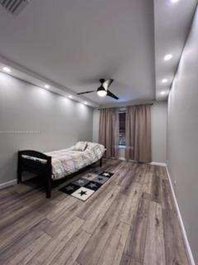 bedroom with ceiling fan and hardwood / wood-style flooring