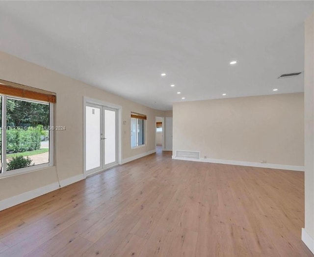 unfurnished living room with french doors and light hardwood / wood-style flooring