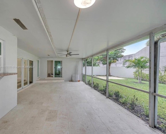 unfurnished sunroom featuring ceiling fan