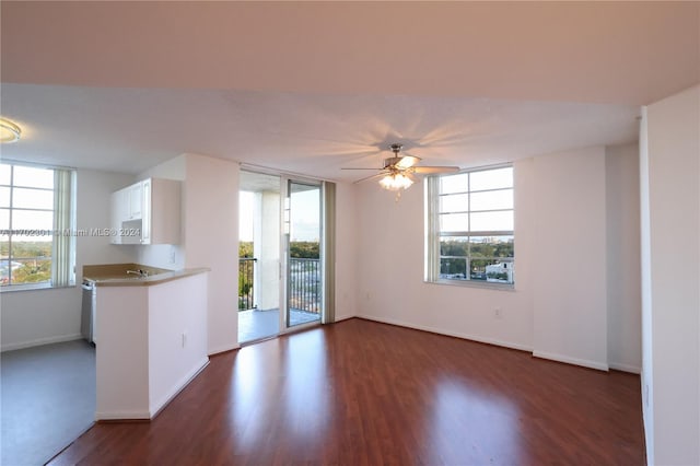 unfurnished living room with dark hardwood / wood-style floors, ceiling fan, and a wealth of natural light