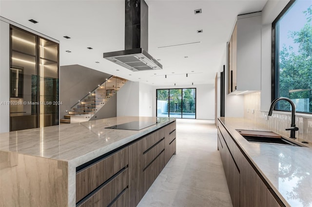 kitchen with ventilation hood, sink, decorative backsplash, black electric cooktop, and light stone counters