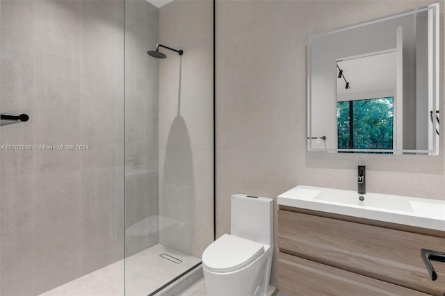 bathroom featuring a tile shower, vanity, and toilet