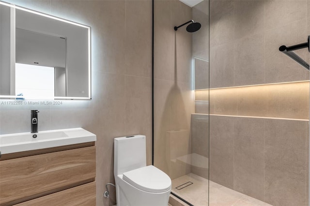 bathroom featuring tiled shower, vanity, tile walls, and toilet