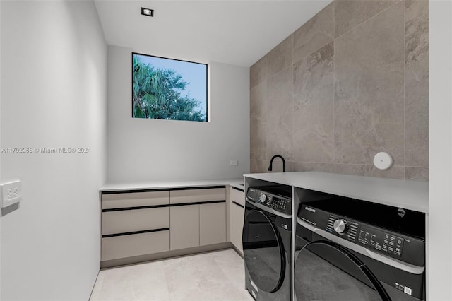 washroom featuring washing machine and dryer and tile walls