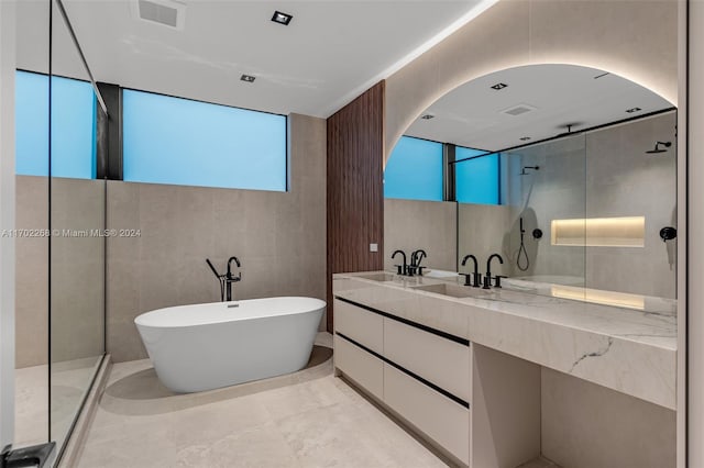 bathroom featuring vanity, independent shower and bath, and tile walls