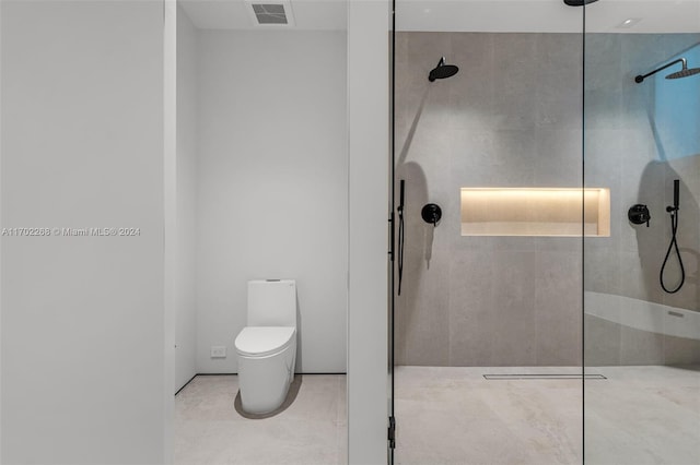 bathroom with tiled shower and toilet