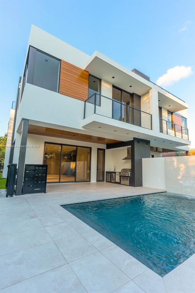 back of property with a patio, a balcony, and area for grilling