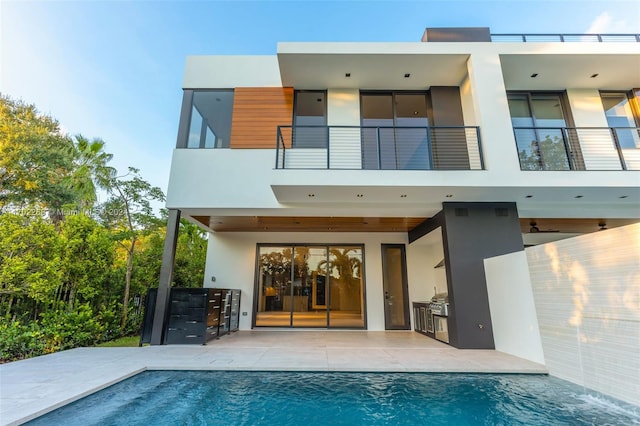 rear view of house featuring a patio, a balcony, and area for grilling