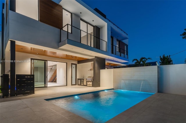 exterior space featuring pool water feature, a patio, and exterior kitchen