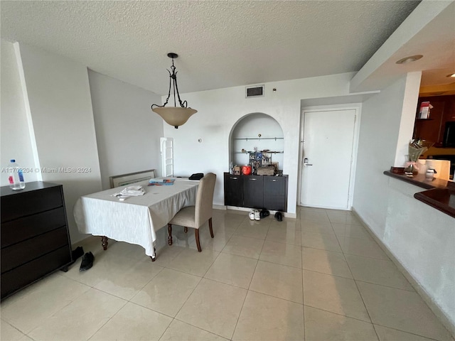 dining room with a textured ceiling and light tile patterned flooring